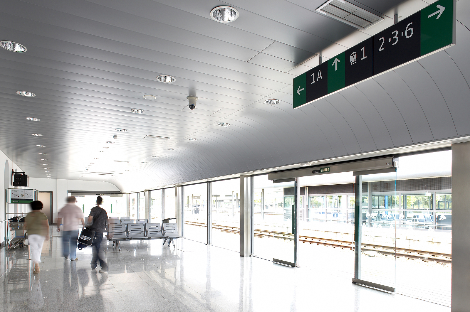Glass door - Railway station hall with people and platforms